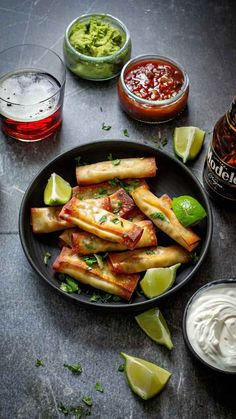 some food is on a black plate with limes and other condiments next to it