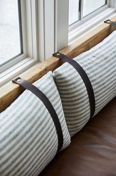 two blue and white striped pillows on a window sill