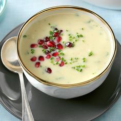 a white bowl filled with soup and garnished with pomegranates