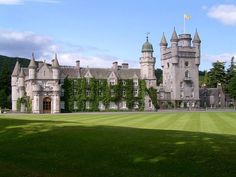 an old castle with ivy growing all over it's walls and roof, surrounded by lush green grass