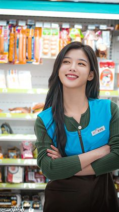 a young woman standing in front of a store shelf with her arms crossed and smiling