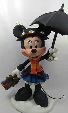 mickey mouse figurine holding an umbrella on top of a white base with black trim