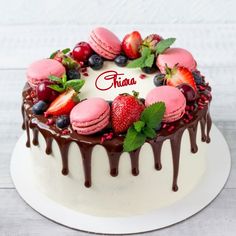 a white cake with chocolate icing and fruit on top