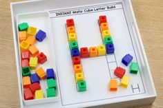 a white tray with legos on it and a letter h in the middle that says instant match cube letter build