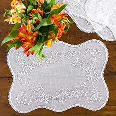 two white place mats with flowers on them