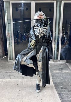 a woman dressed as darth vader standing in front of a building