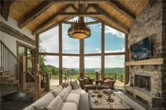 a living room filled with lots of furniture and a fire place in front of a large window