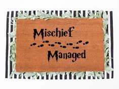 a door mat with the words mischef managed on it and leaves around it