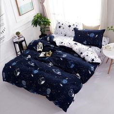 an image of a bedroom setting with space themed bedding and pillows on the floor