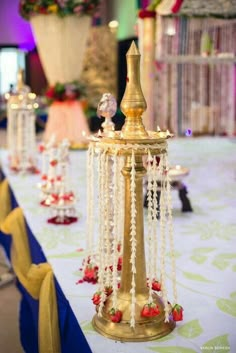 a table topped with lots of gold and white decorations on top of a blue table cloth