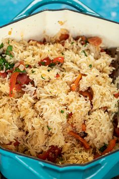 a blue casserole dish filled with rice and vegetables