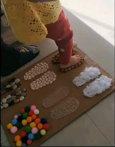 a child standing on top of a brown mat covered in lots of different candies