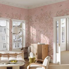 a living room filled with furniture and pink walls