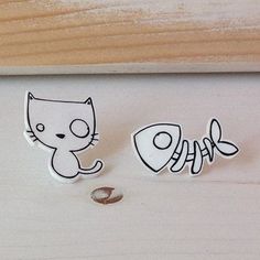 two magnets with the word fish and a cat sitting on top of each other