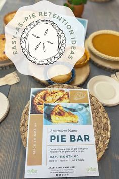 a pie bar sign sitting on top of a wooden table next to plates and cups