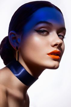 a woman with bright blue hair and orange lipstick is shown in an artistic fashion photo