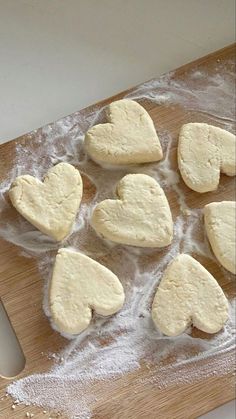 some heart shaped cookies are on a cutting board