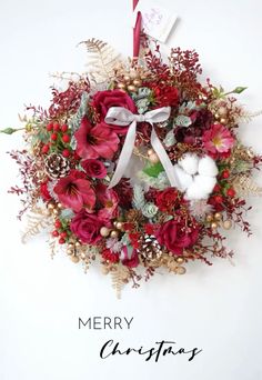 a merry christmas wreath with red flowers and greenery on the front, white background