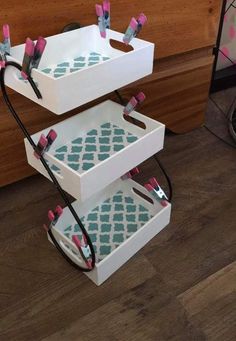 three white boxes with pink and blue designs stacked on top of each other in front of a counter