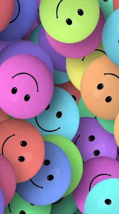 many different colored balloons with faces drawn on them