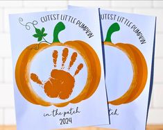 two little pumpkins with hand prints on them