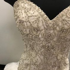 the back of a wedding dress with beading and sequins on display in a store