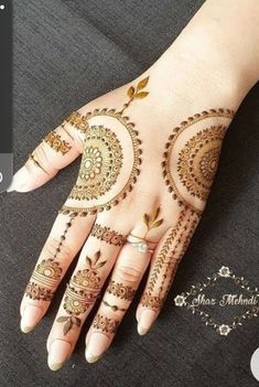 a woman's hand with henna tattoos on it