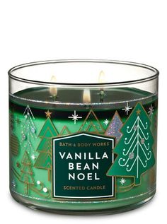 a candle that is sitting in front of a white background with green trees on it