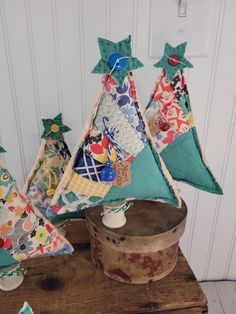 three pieces of fabric sitting on top of a wooden table next to a potted plant