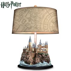 a lamp that is sitting on top of a table next to a paper shade with hog potter's map on it