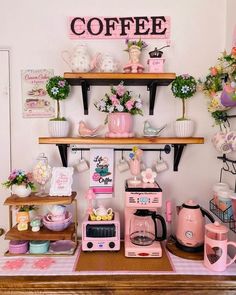 a coffee bar with pink appliances and decorations on the shelves above it is decorated with flowers