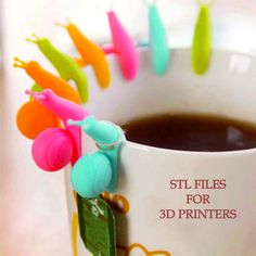 a coffee cup filled with lots of different colored plastic items on top of a table