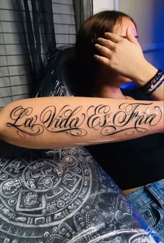 a woman with a tattoo on her arm and the words la wild & free written in cursive font