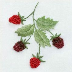 some raspberries and leaves on a white surface