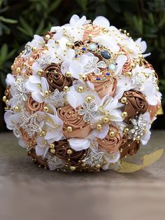 the bridal bouquet is made up of white and brown flowers with gold accents on it