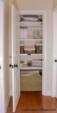 an open closet with baskets and towels in it