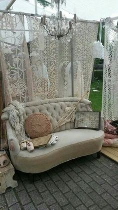 a couch sitting on top of a brick floor next to a white net covered wall