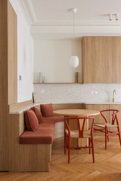 a kitchen and dining room with wood flooring, white walls and wooden table and chairs