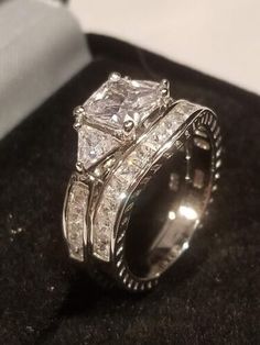 a couple of wedding rings sitting on top of a black table next to a book