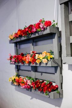 flowers are arranged on the side of a wall