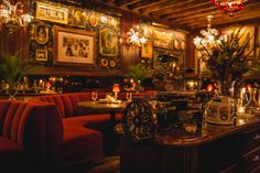 a restaurant with red velvet booths and chandeliers hanging from the ceiling, along with candles