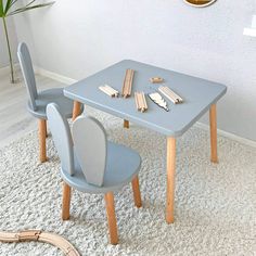 a blue table and chairs in a room with a clock on the wall behind it