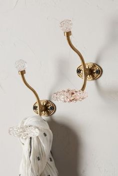 a pair of sconces on a wall with white fabric wrapped around the handles