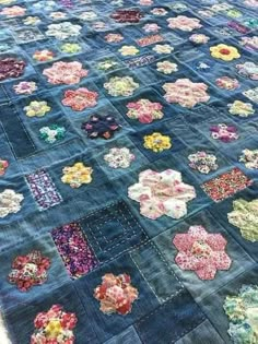 an old quilt is laying on top of a tablecloth that has been stitched together