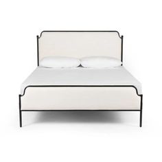 a white bed with two pillows on top of it and a black frame around the headboard