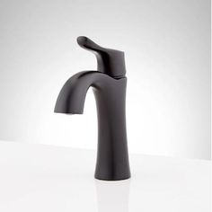 a black faucet on a white countertop with no one in the photo