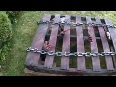 an outdoor table made out of pallets with chains on it