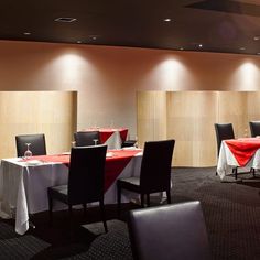 a dining room with tables and chairs covered in red and white tablecloths