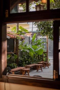 an open window with benches and plants outside