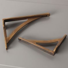 two pieces of wood sitting on top of a table next to each other in the shape of an arrow